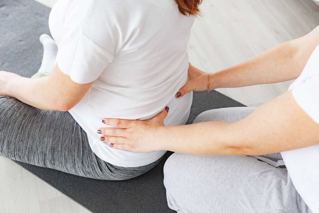 a person touching the back of a woman